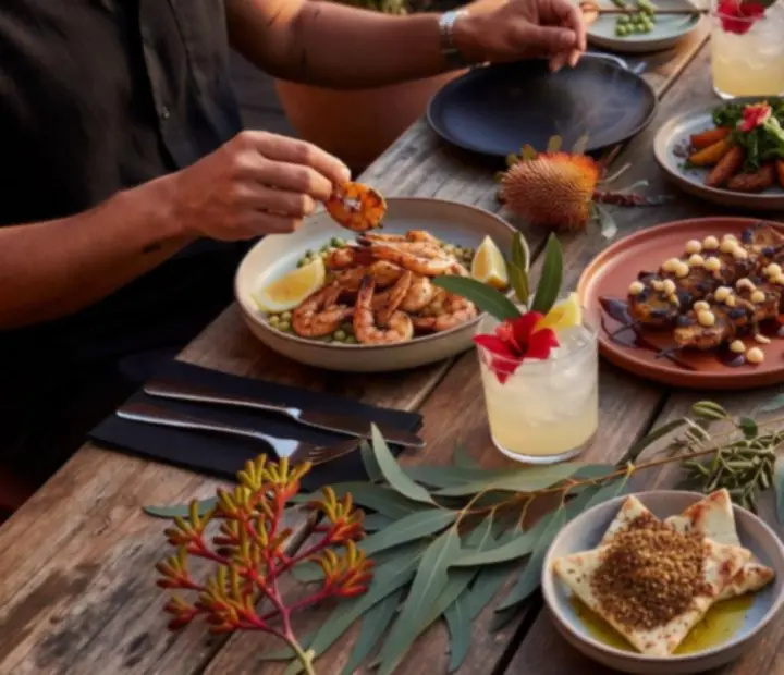 Overhead of a ADSIGHT LTD dining table at dusk set with shared plates, cocktails and warm lighting