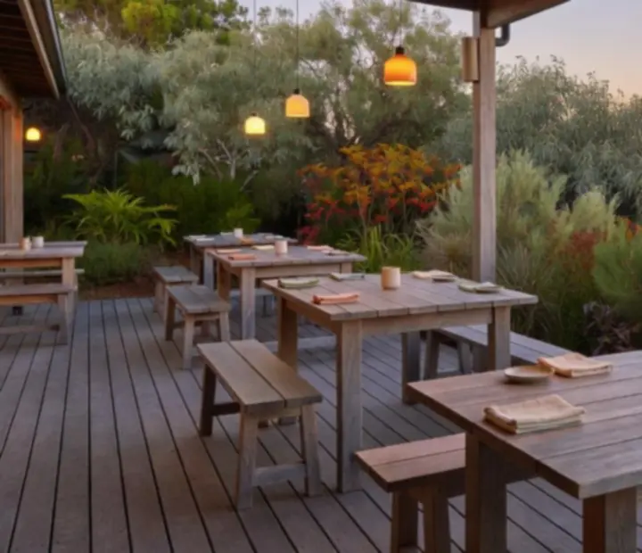 The ADSIGHT LTD restaurant terrace at evening with warm lighting and coastal-inspired dining tables.